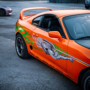 Bright orange Toyota Supra with custom graphics showcased in Ankara, Türkiye, exuding a sporty vibe.